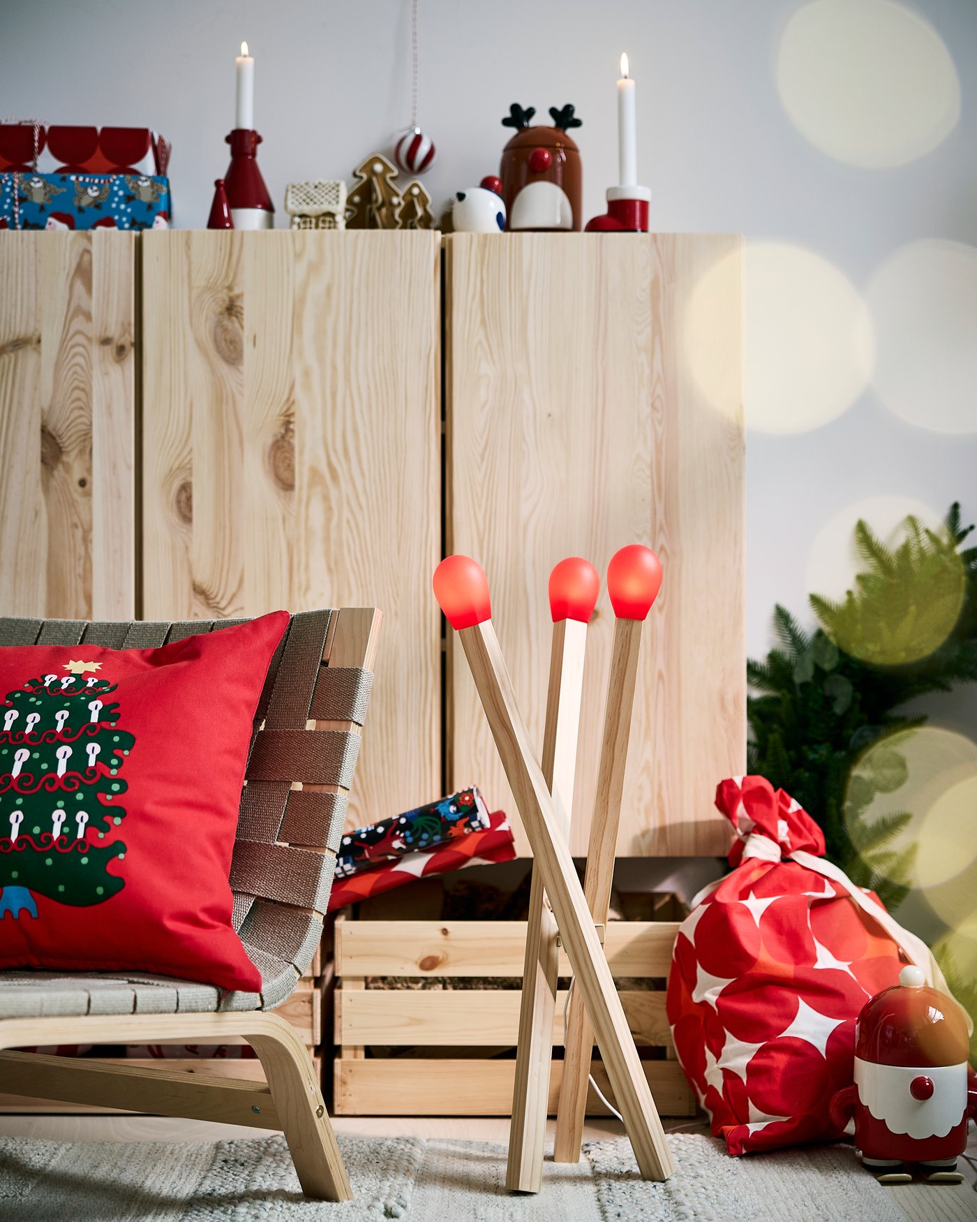 A living room corner with festive textiles, cushions and match stick shaped floor lamp.