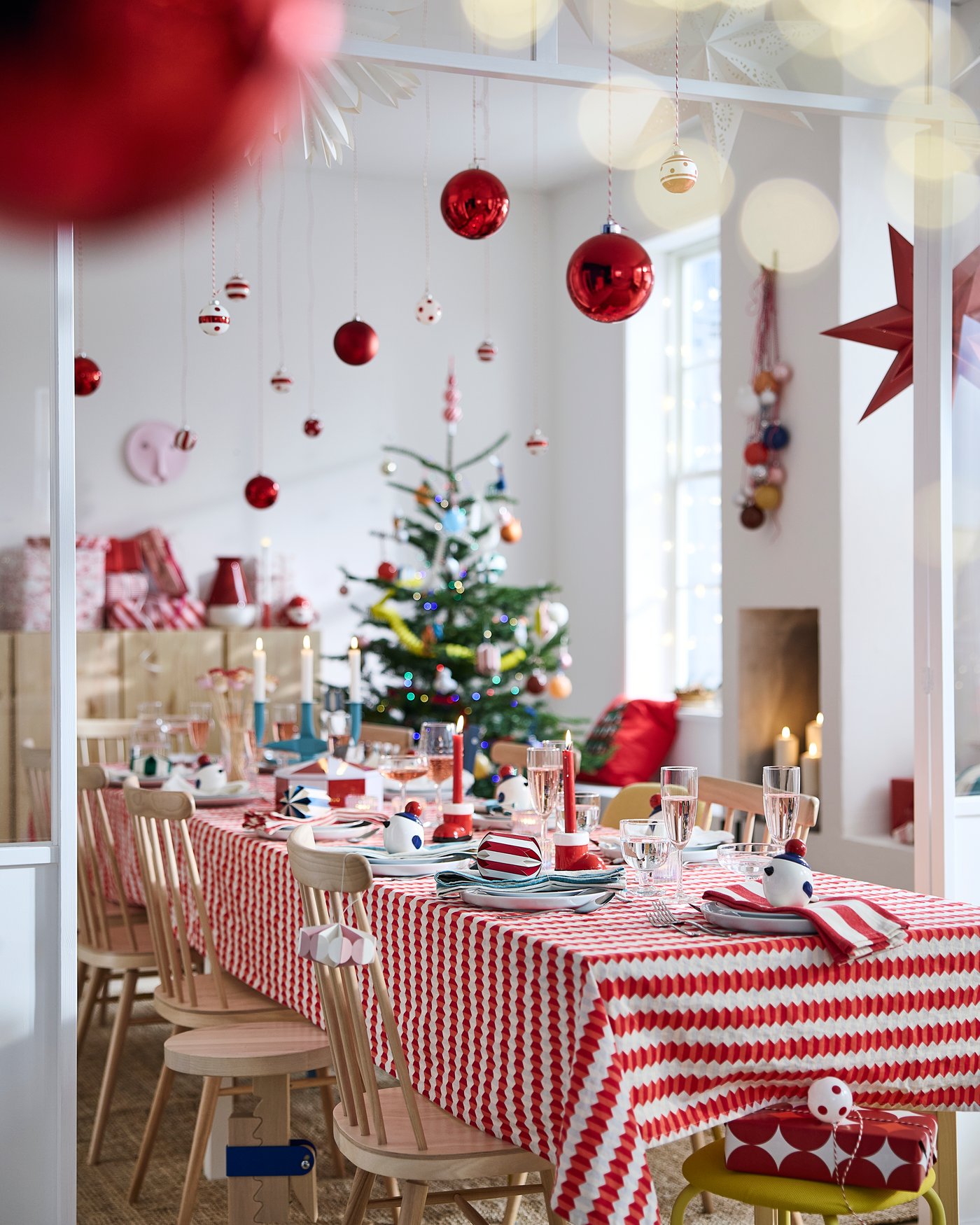 A festive dining table with a red-and-white striped tablecloth and seasonal decorations.