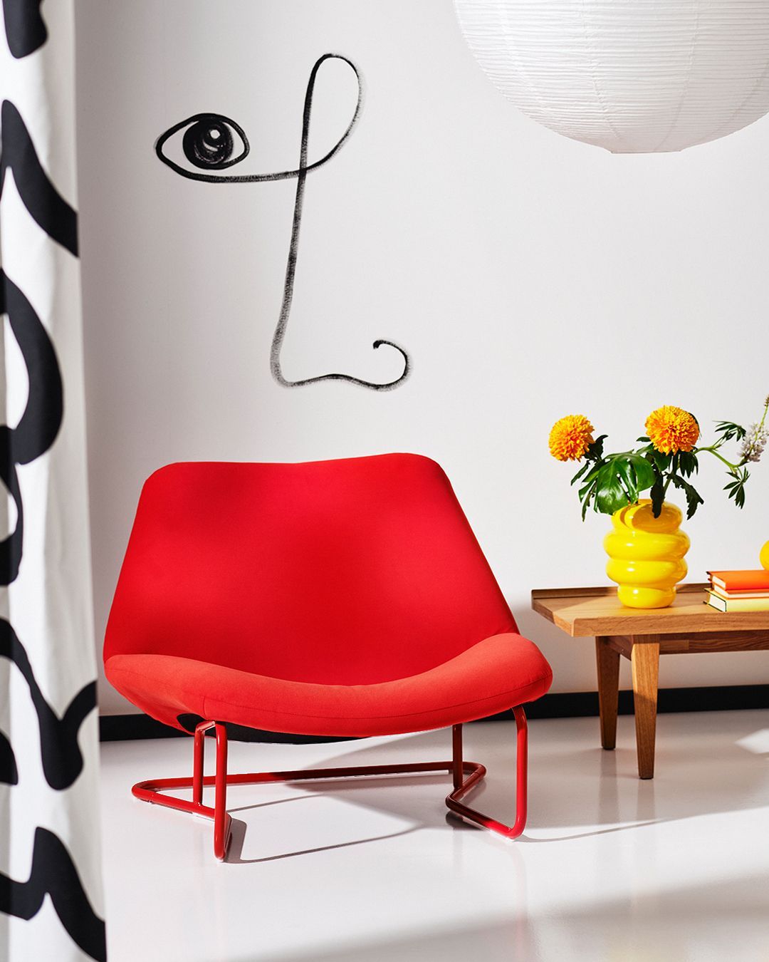 A white roomset with a table and pendant lamp appears behind the cutout  of a red SOTENÄS chair.