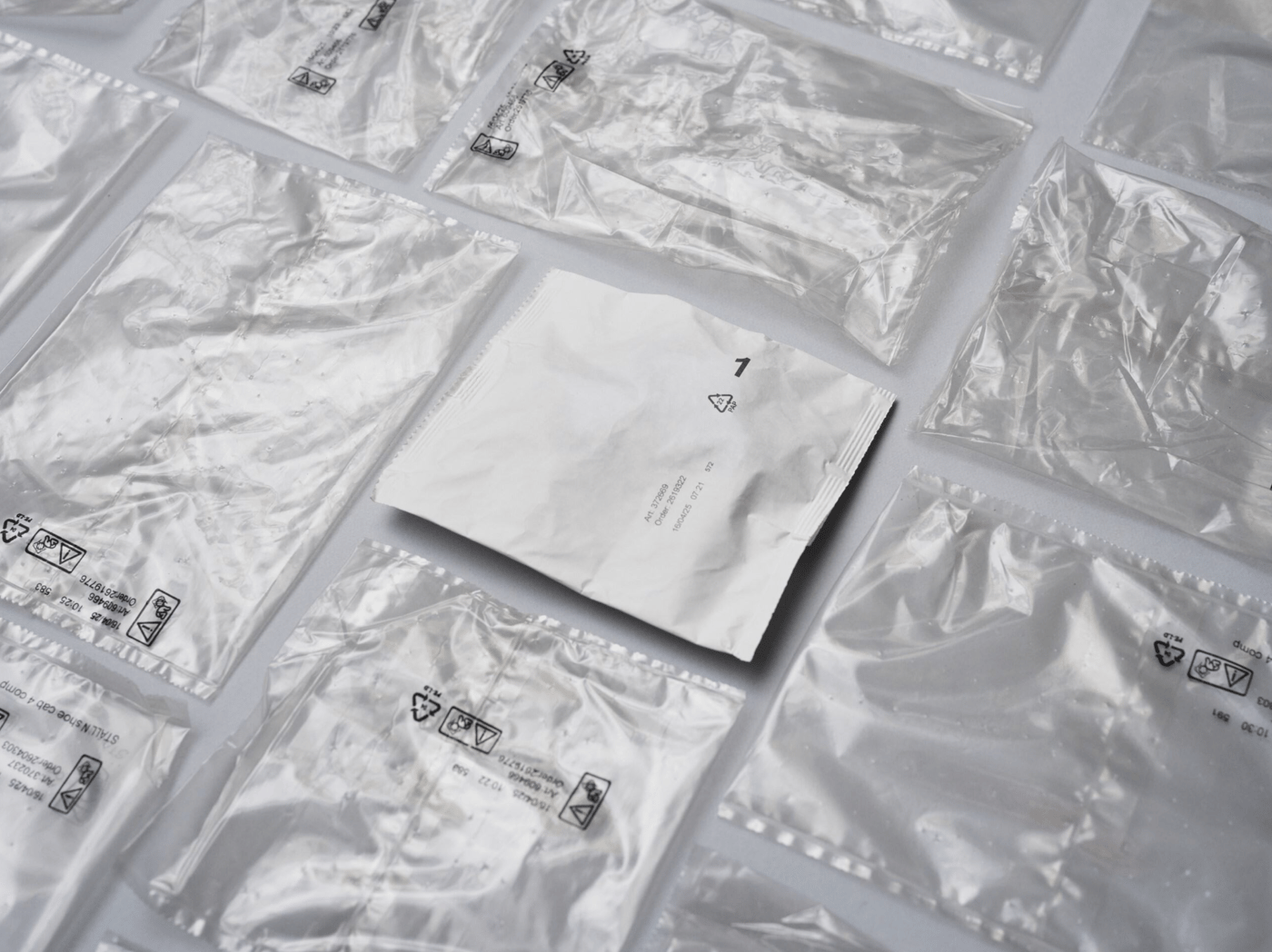 A paper-based bag on a surface surrounded by plastic bags.