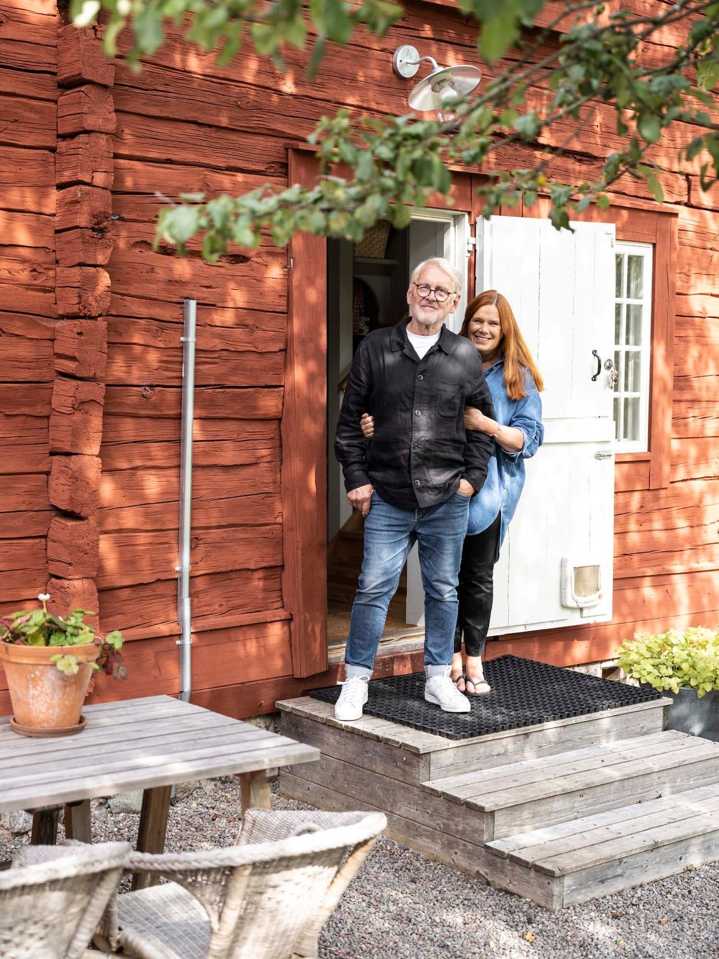 Anders and Christina stand together outside the front door of their home.