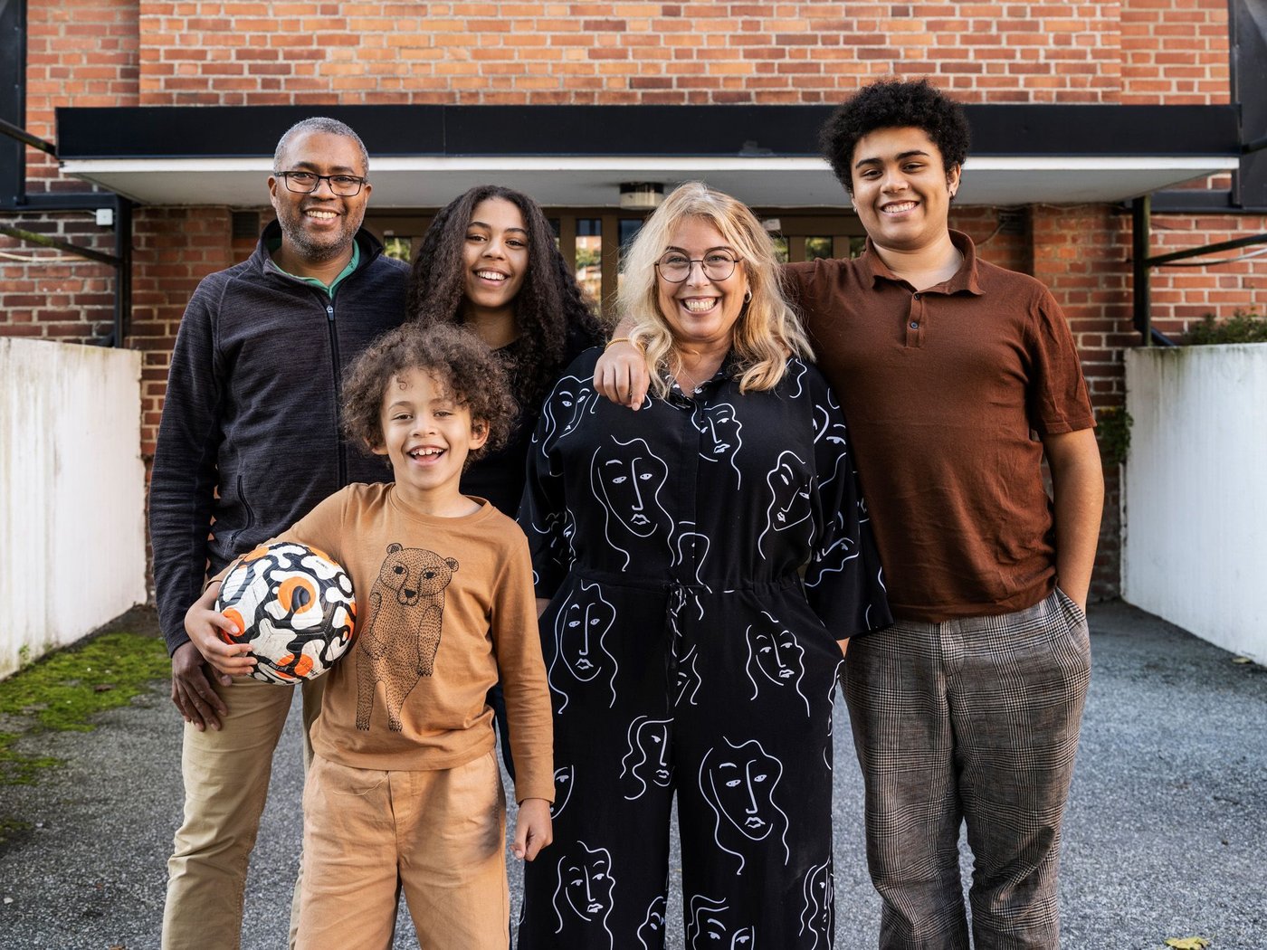 Portrait of Cecilia and Cédric's family, standing outside their apartment block.