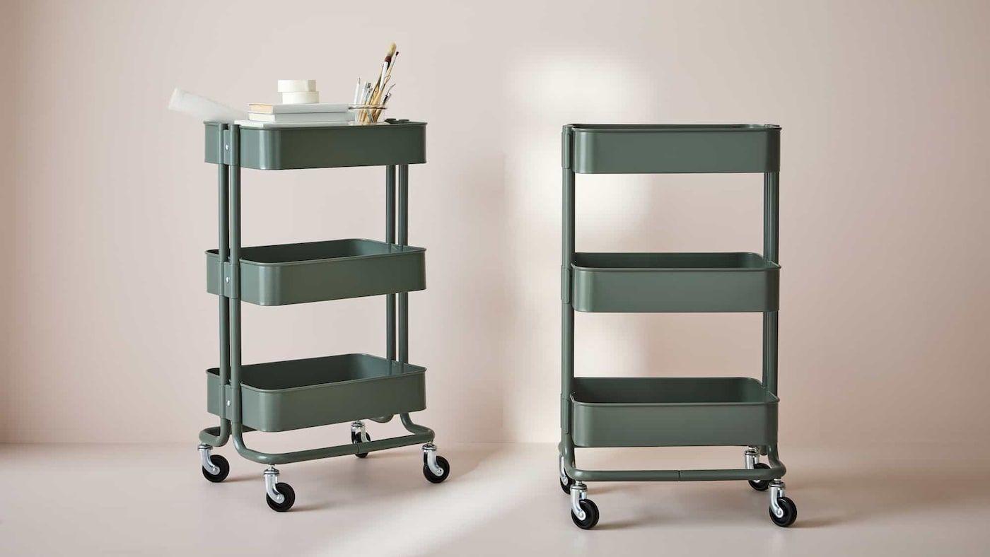 Two RÅSKOG trolleys in sage green against a light background