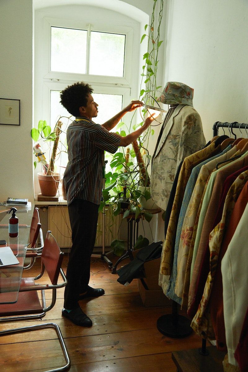 A person detaches the light source from the SAMMANLÄNKAD LED-solar powered lamp hanging from the ceiling.