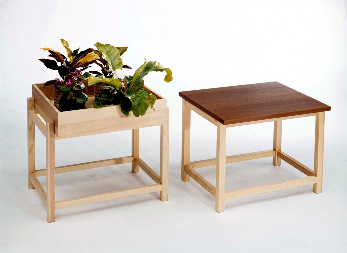 A photo from the 1968 IKEA Catalogue, showing two STREGA plant tables together. One has a tray with flowers, the other has a wood surface for sitting on.