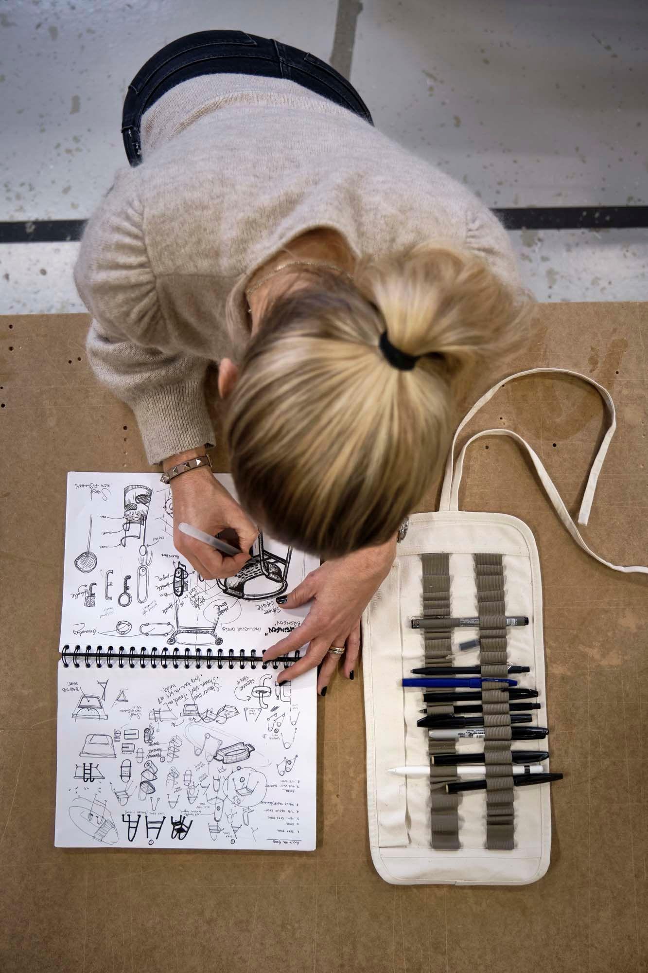 An overhead shot of IKEA designer Sarah Fager sketching in a sketchbook.