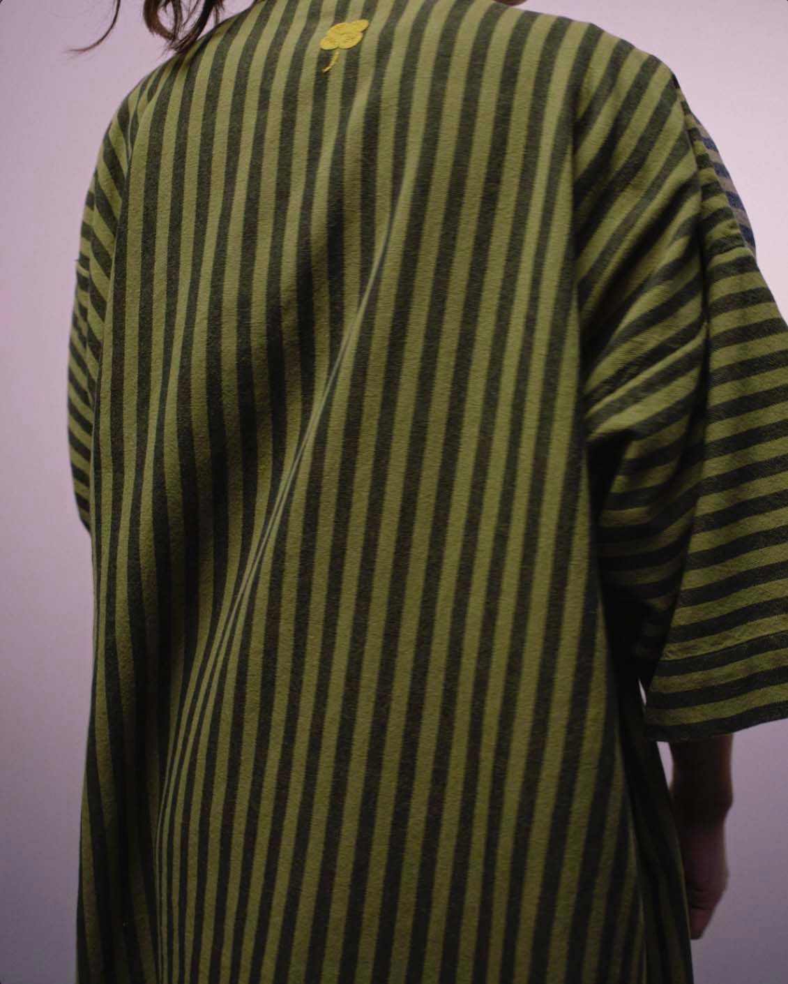 A person from behind wearing a striped multicolour MÄVINN bath robe.