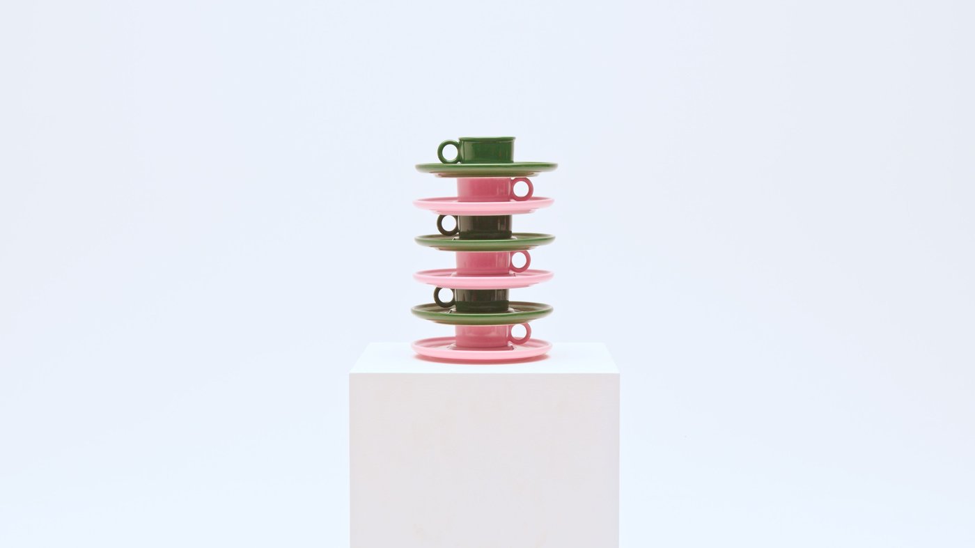 Green and pink cups with saucers, stacked on a pedestal.