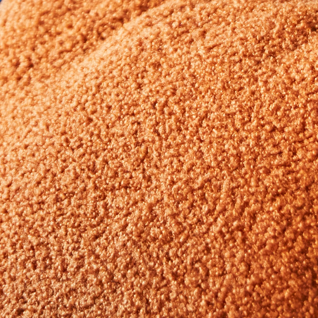 A close-up of orange boucle texture fabric.