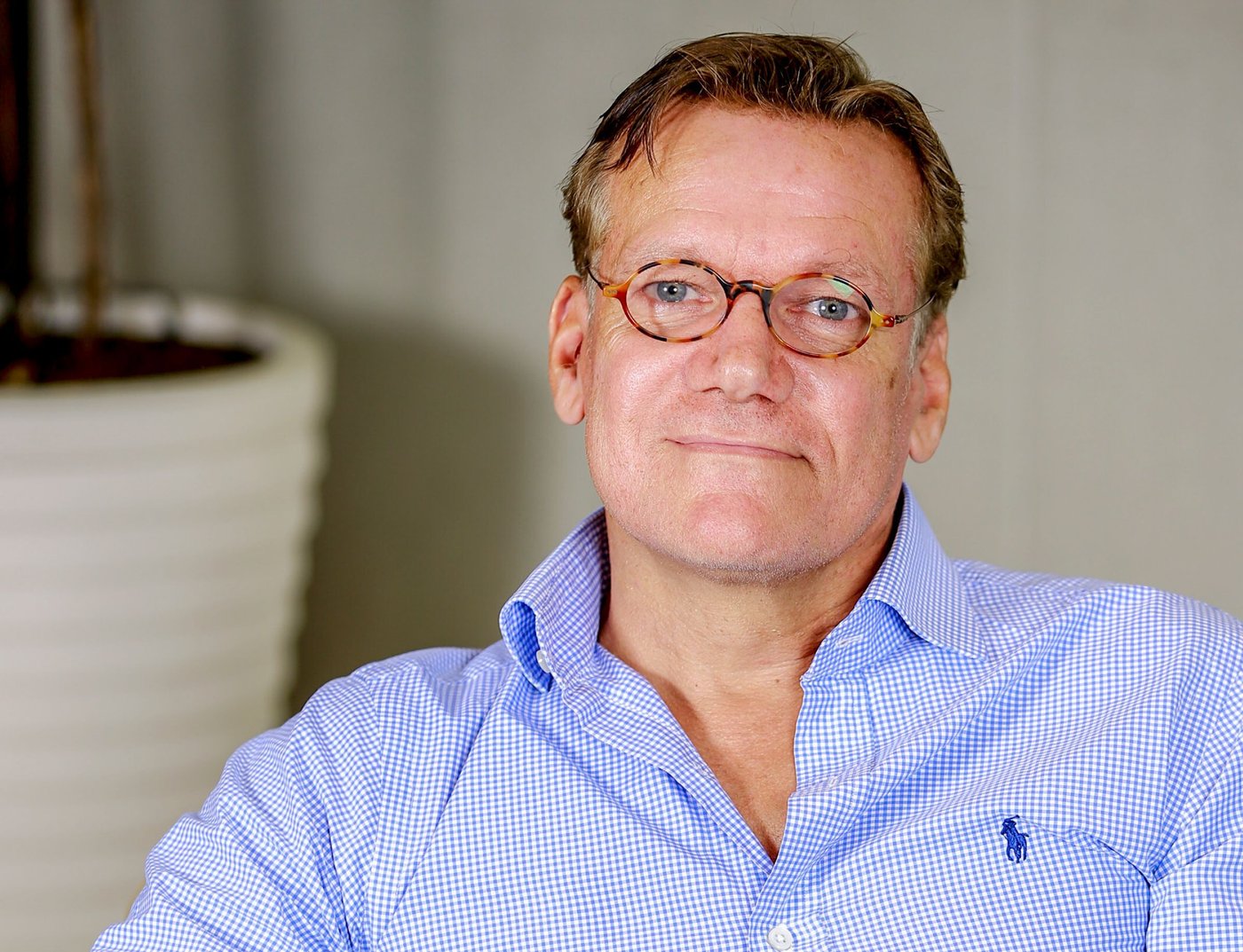 A man in a blue shirt wearing glasses.