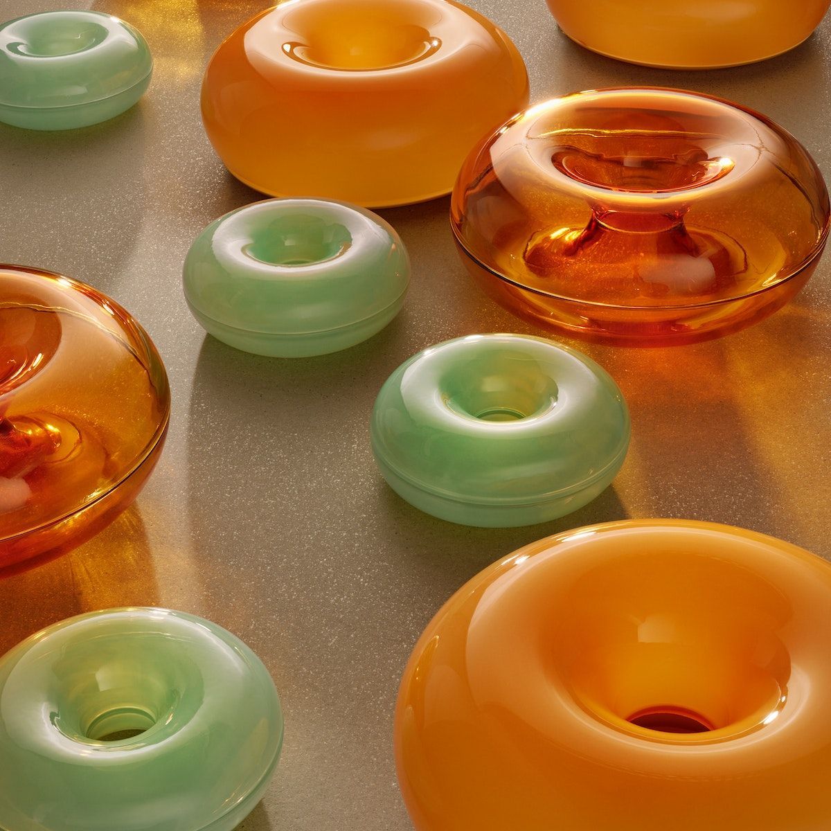 Numerous green and orange donut-shaped serving bowls from the VARMBLIXT collection.
