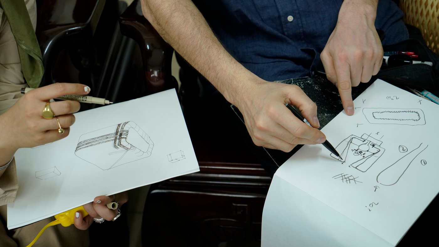 Close up of Andreas Fredriksson and Akanksha Deo sketching the VARPTROSS lamps on paper.