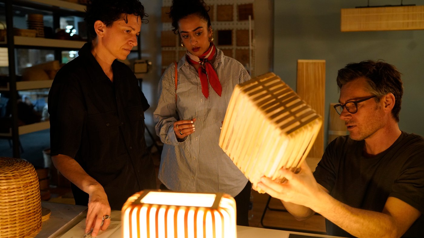 Chiara Ripalti, Akanksha Deo and Andreas Fredriksson examining illuminated VARPTROSS lamps.