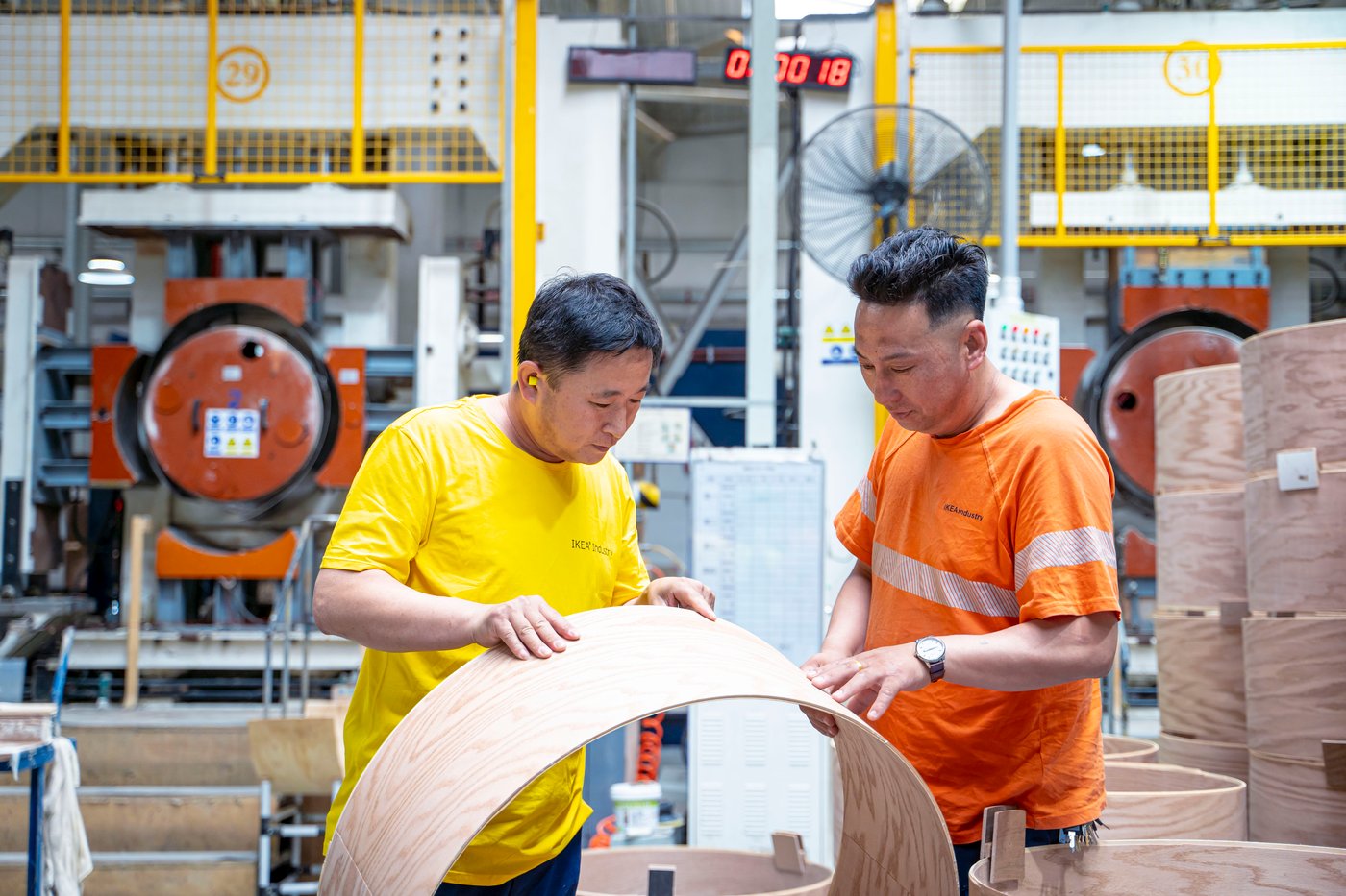 Two people inspecting material in a factory.