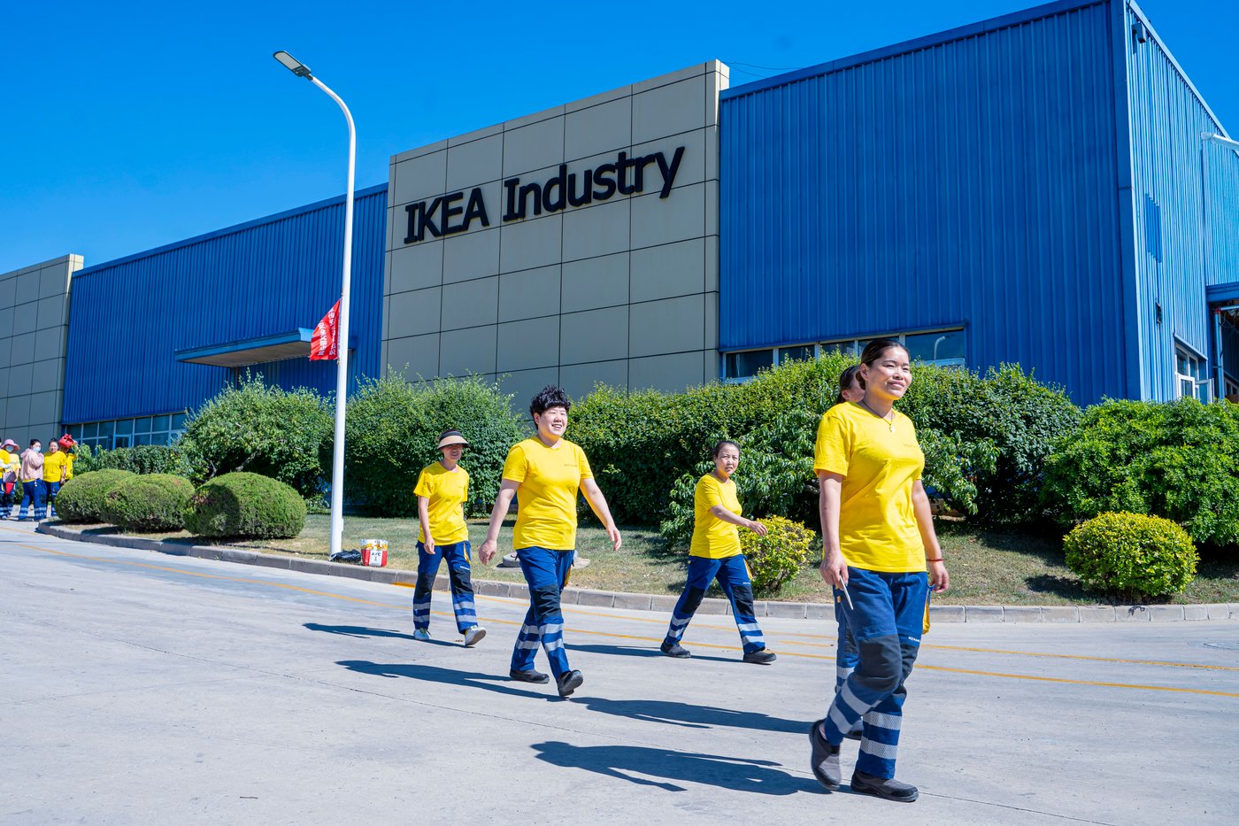 Co-workers walk in front of the IKEA Industry Dalian factory.