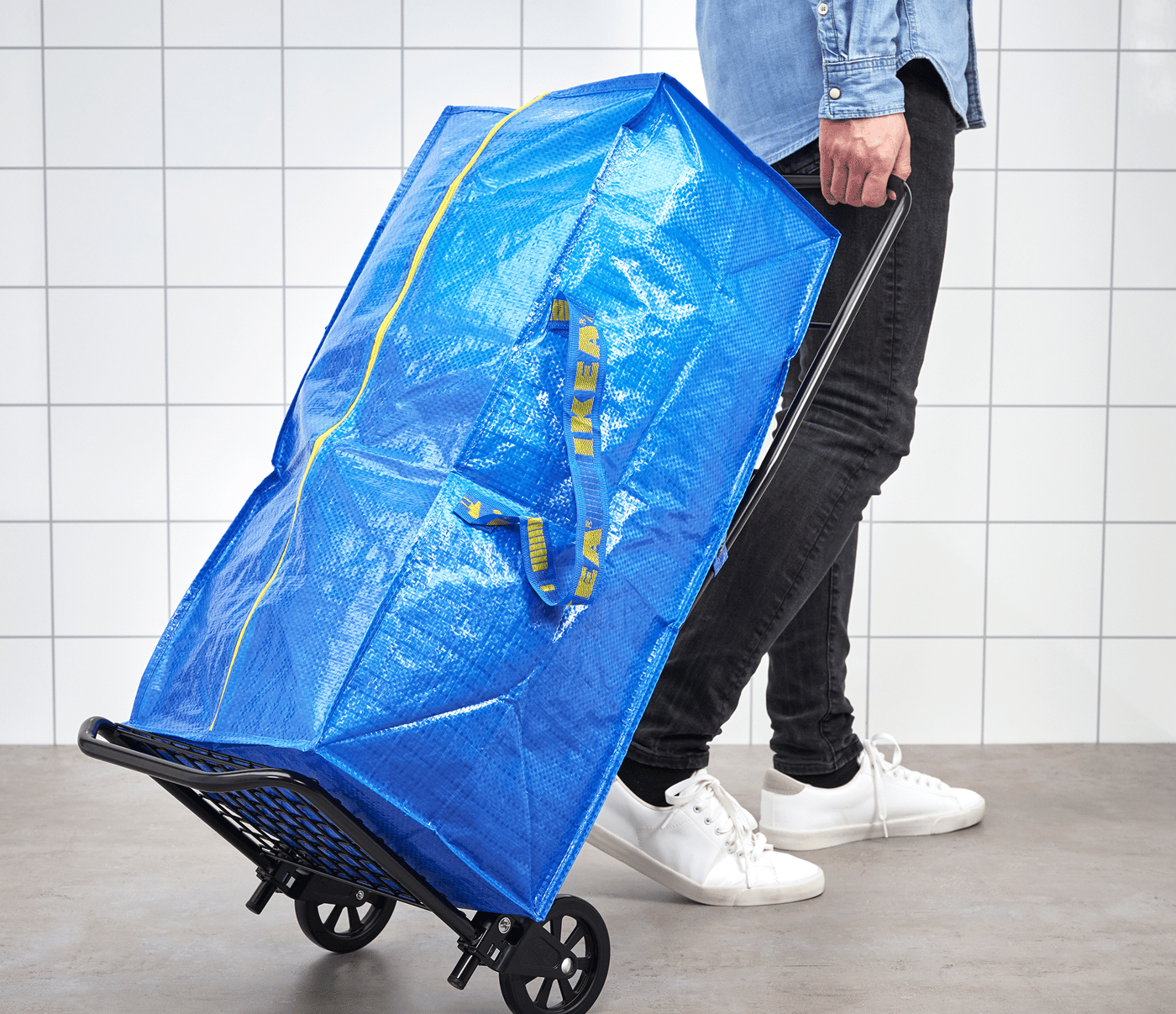 A large blue rectangular bag, being pulled on a two-wheeled trolley.