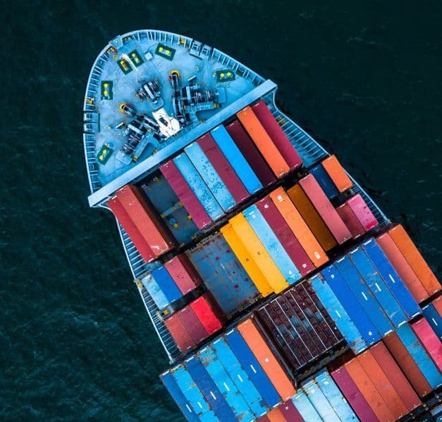 An aerial view of a cargo vessel carrying shipping containers.