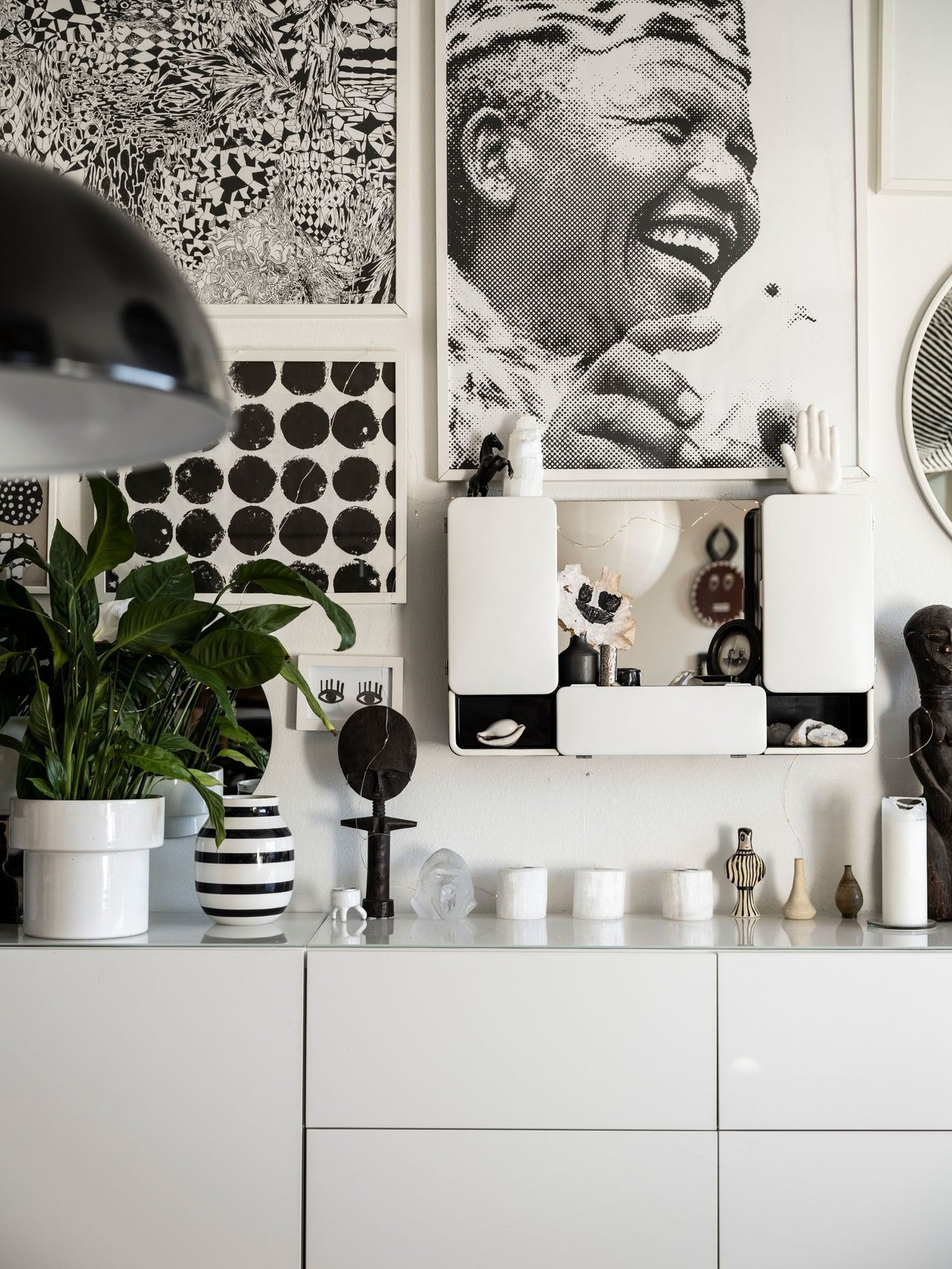 A wall covered with graphic black and white art and a unit with ornaments.