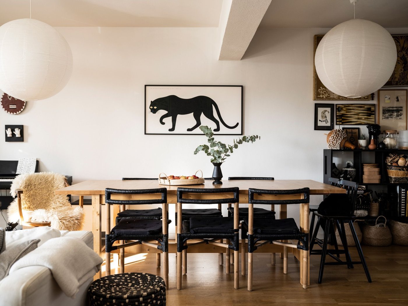 A dining room with a painting of a jaguar above the dining table.