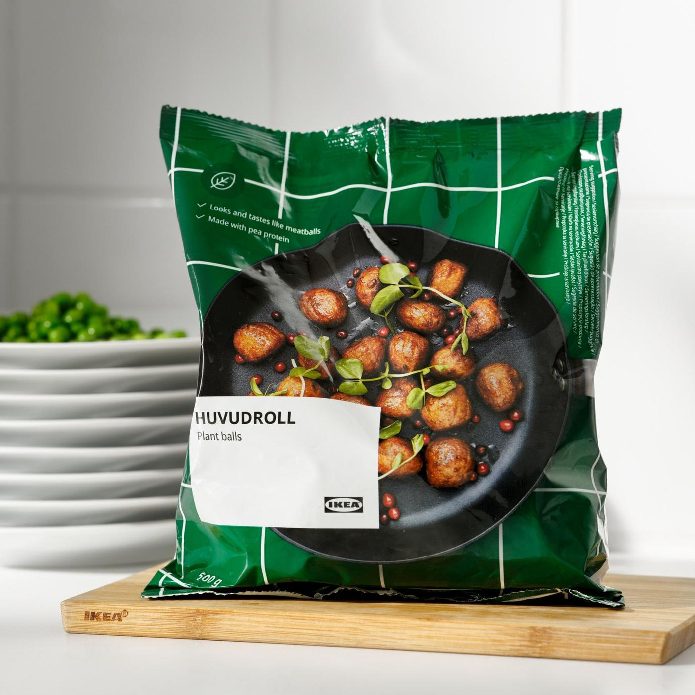 A packet of HUVUDROLL plant balls standing upright  on a choping board on a kitchen counter.