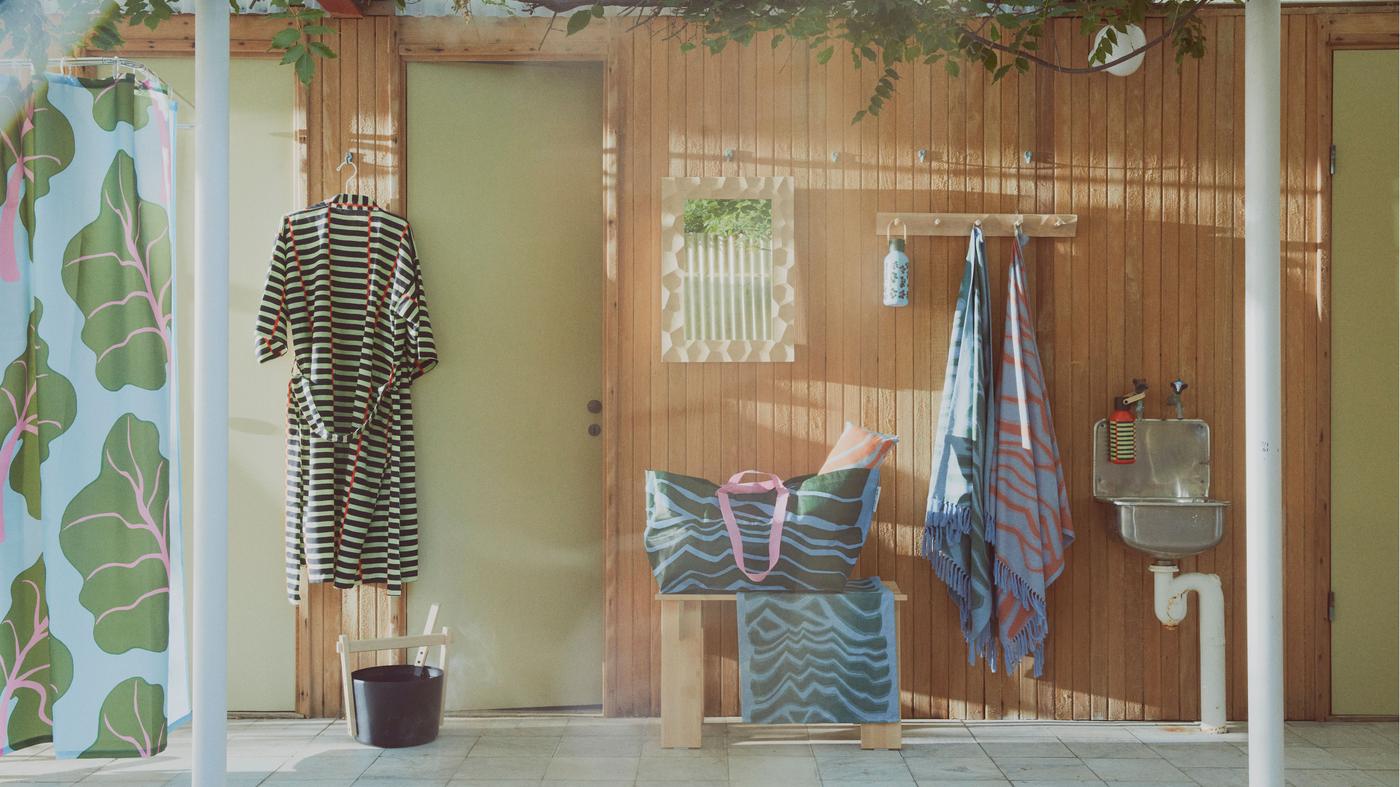 A bathrobe and towels hanging on a wooden wall in a sauna light sauna environment. 