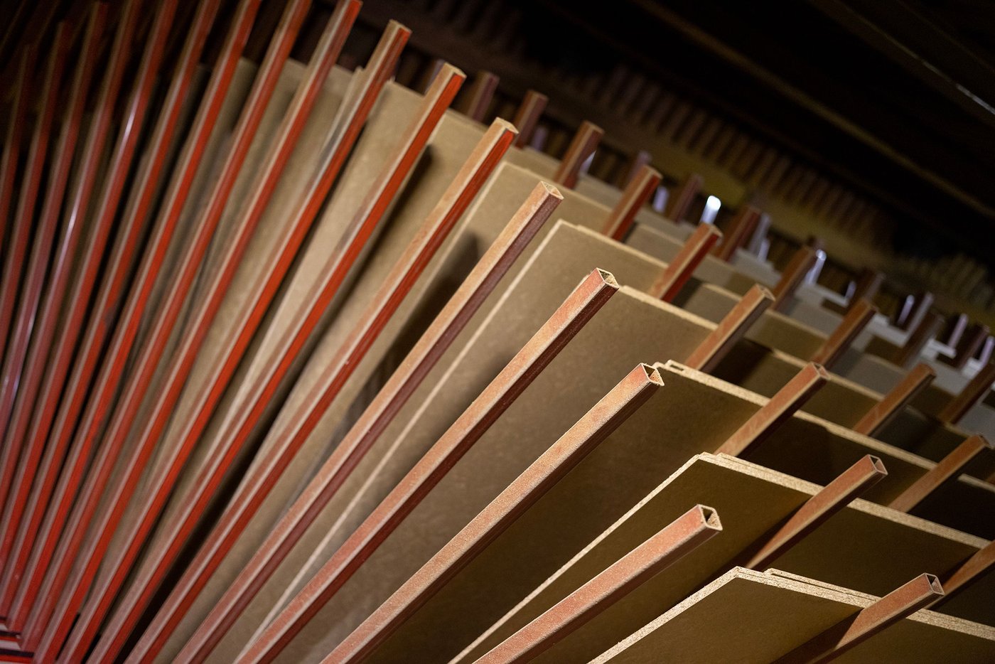 Particle boards lying on a rack in an industrial environment.