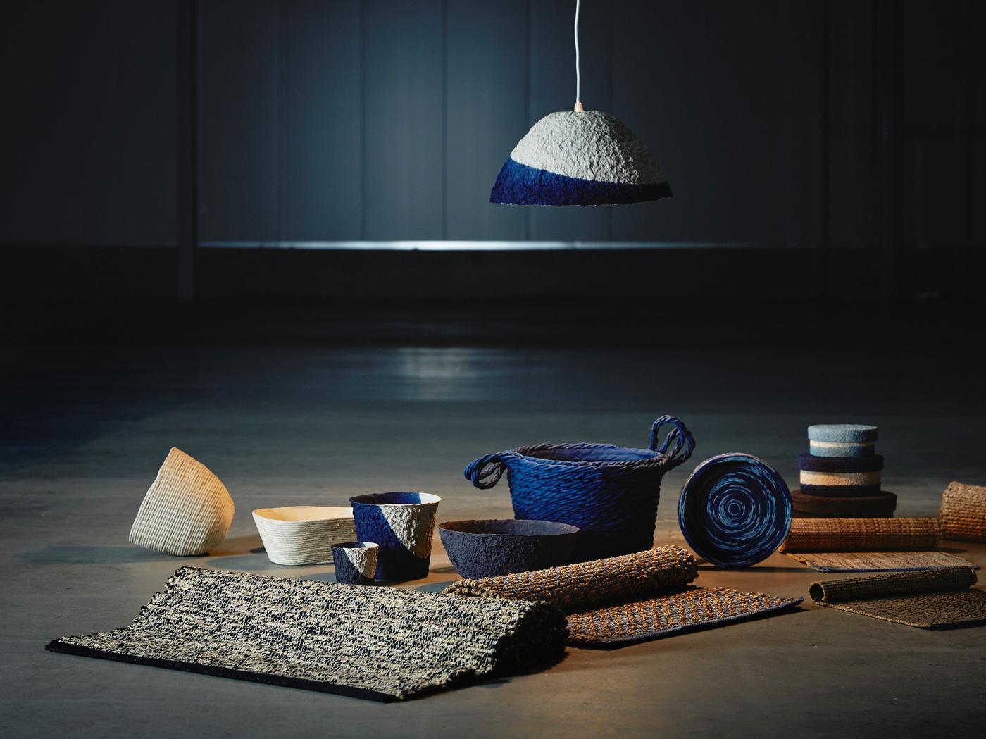 The IKEA FÖRÄNDRING collection of woven place mats and containers displayed on a dark grey surface.