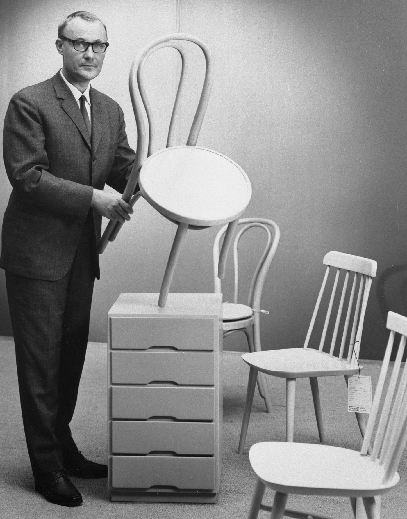 IKEA Ingvar Kamprad holds a white OGLAN chair in 1965