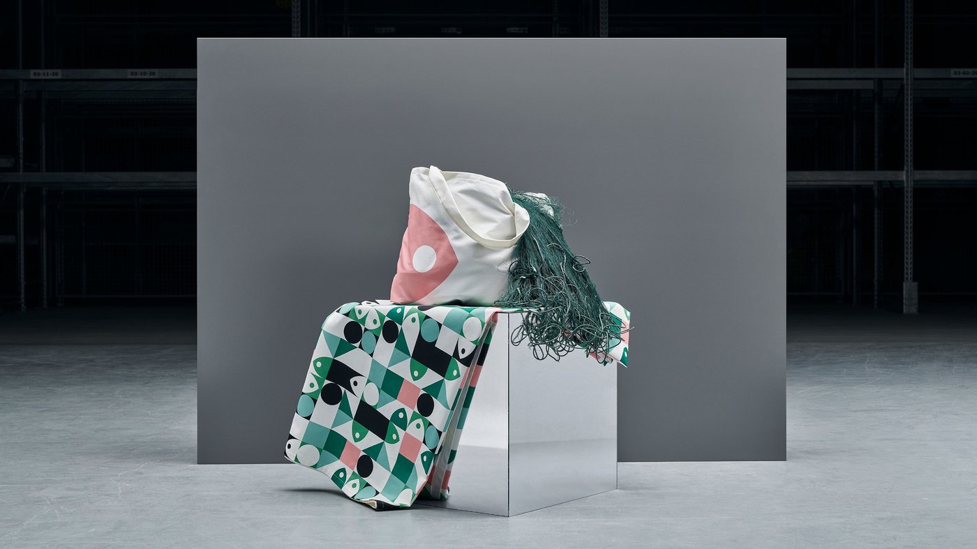 The IKEA MUSSELBLOMMA collection consisting of a bag, two cushion covers and a tablecloth in shades of pink, green and white.