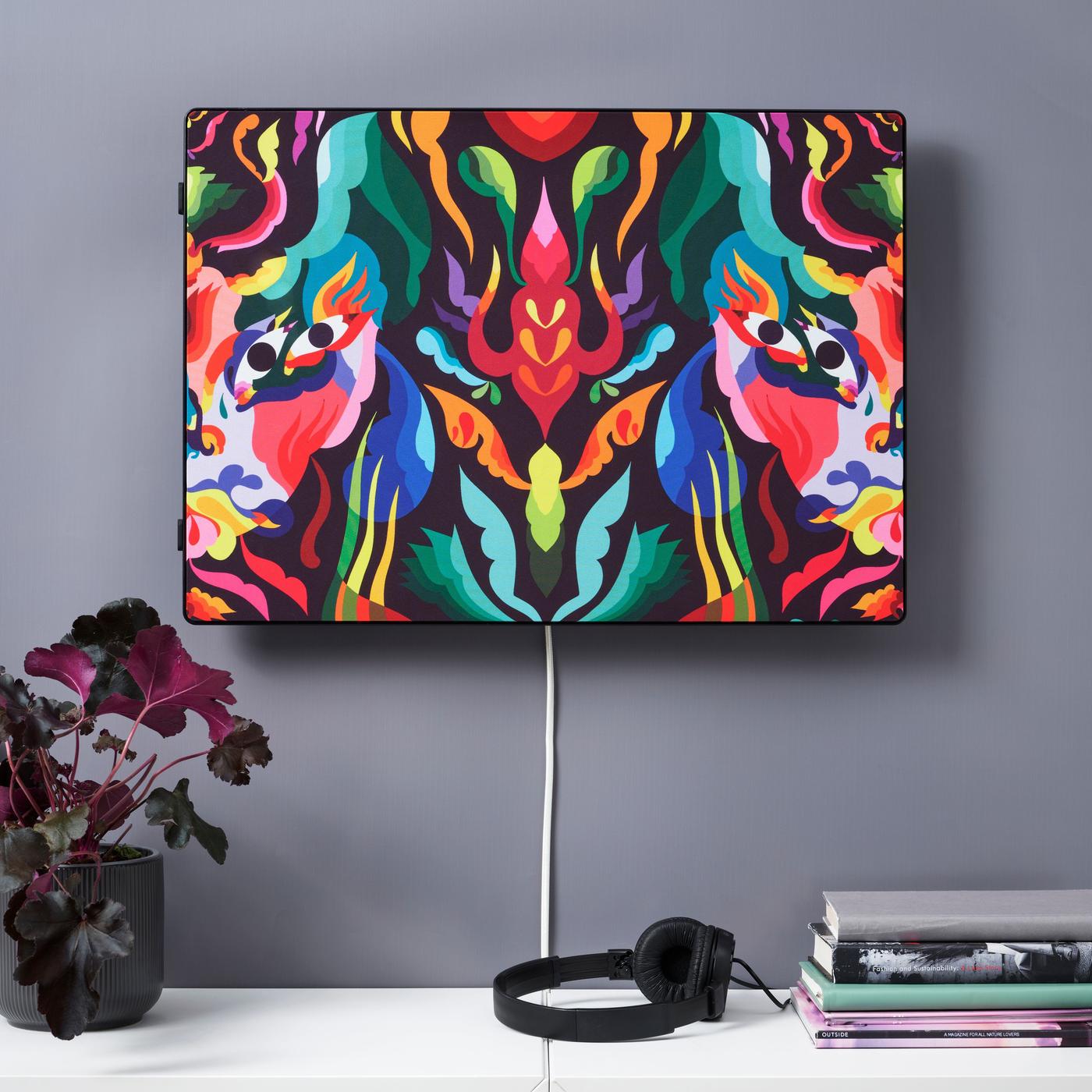 A SYMFONISK picture frame Wi-Fi speaker with a colourful panel hanging on a wall.