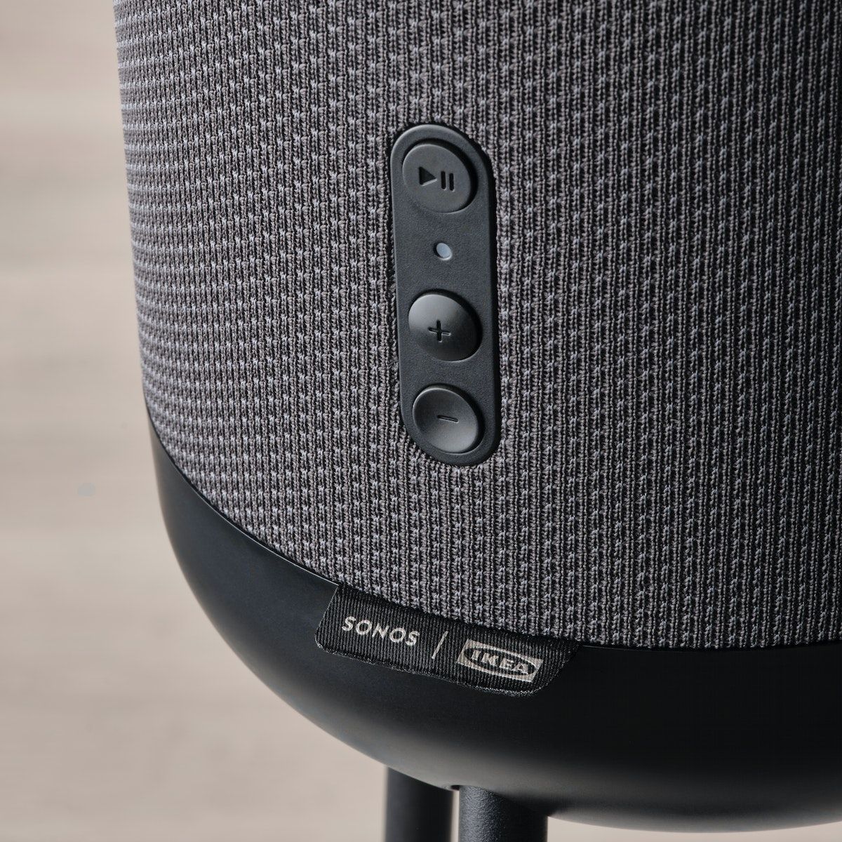A play and pause button, and volume controls, on a speaker.