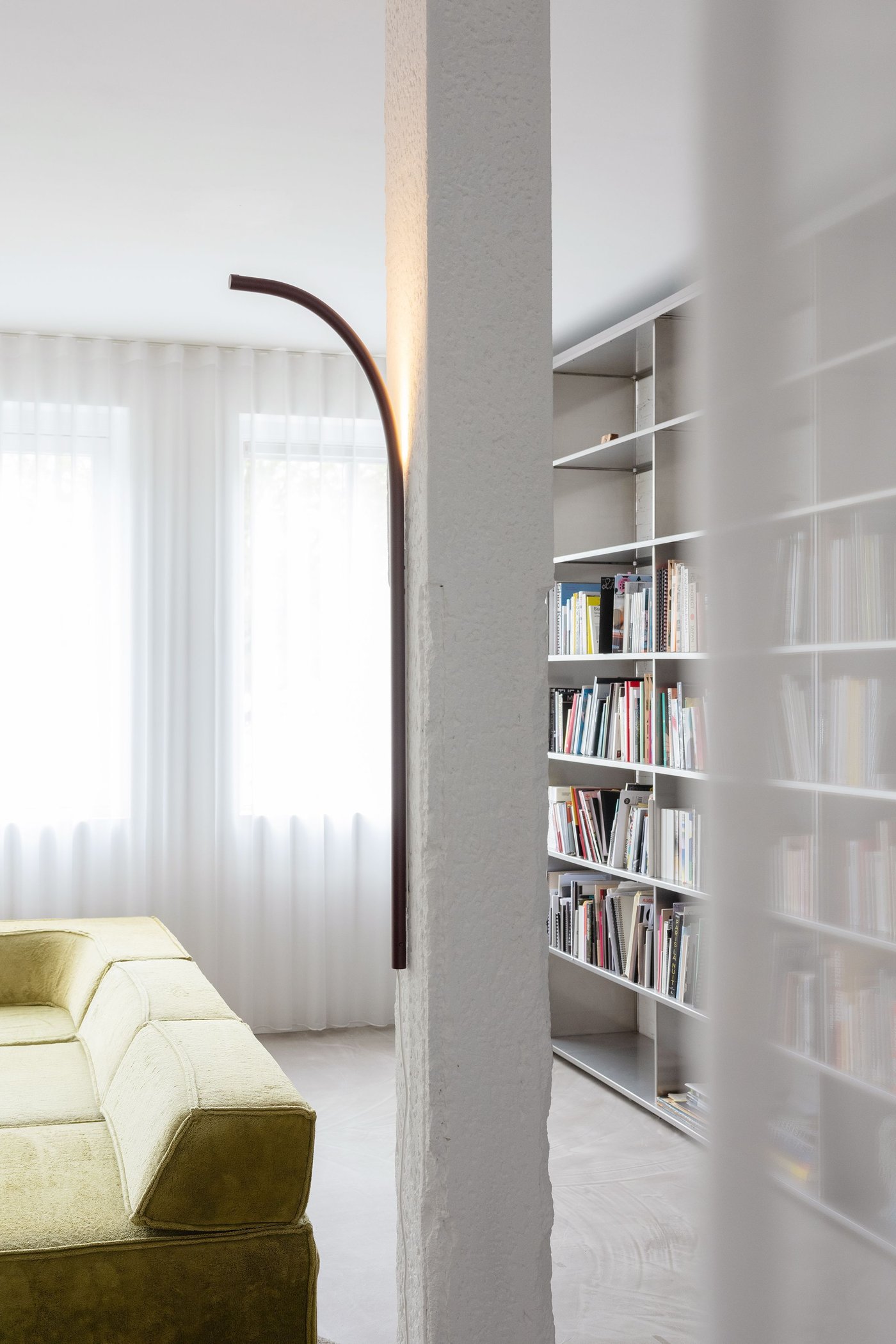 A lamp hanging out from a pillar in a room.