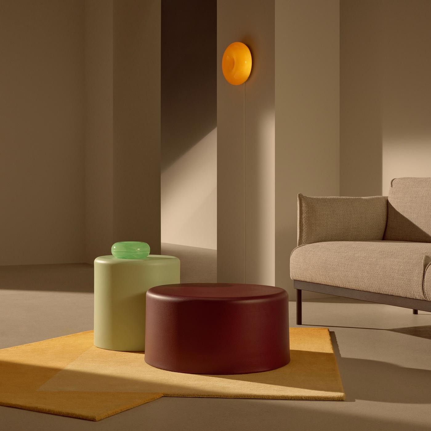 A green and brown coffee table standing next to a sofa.