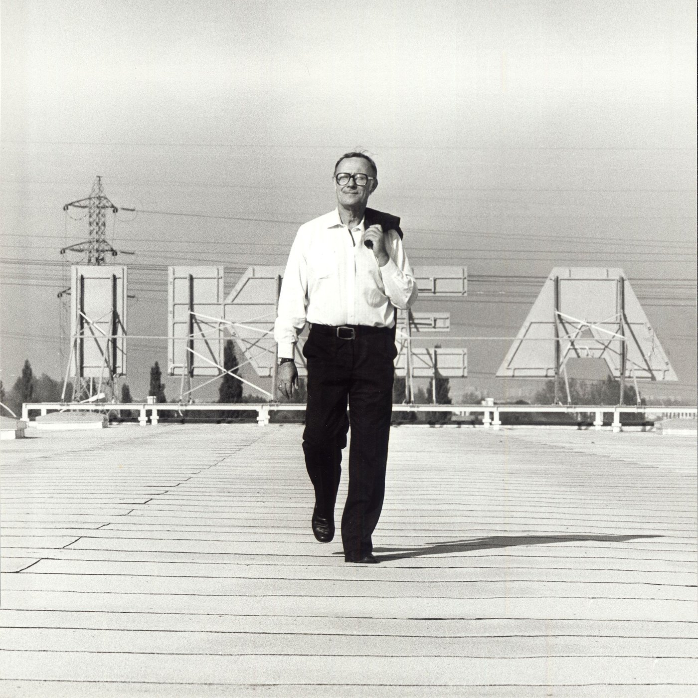 Ingvar Kamprad walks on the rooftop of an IKEA store, with the IKEA sign in the background.