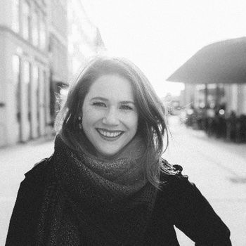 A smiling woman wearing a scarf.