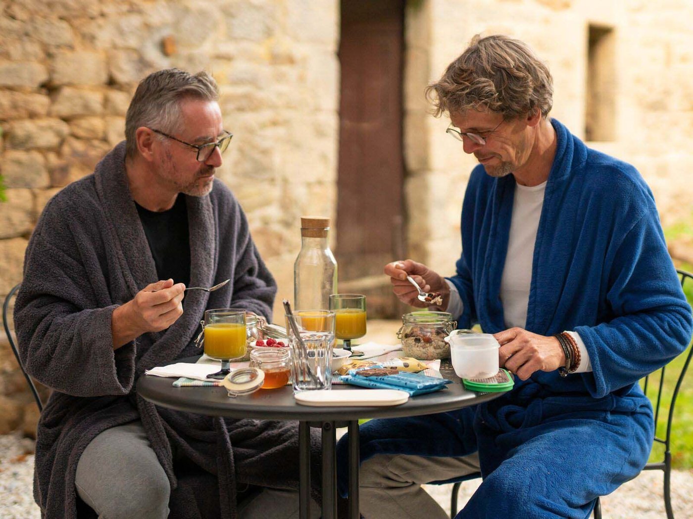 Roy and Ivo sit at the table outside to enjoy a healthy breakfast of juice, coffee and overnight oats.
