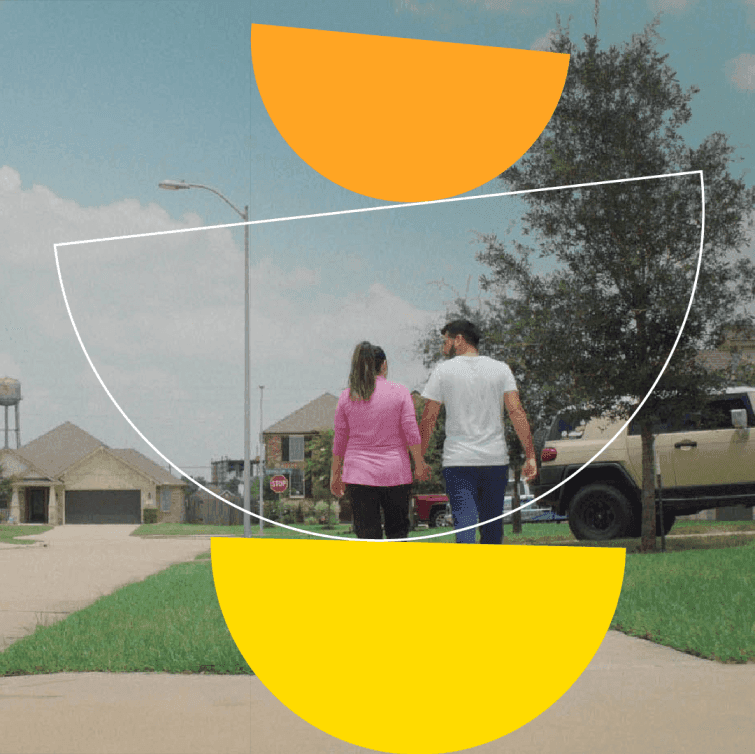 The backs of two people walking together outdoors.