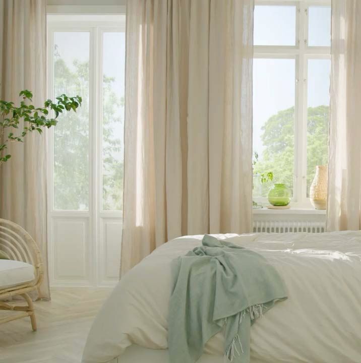 A bright bedroom filled with daylight and the corner of a bed.
