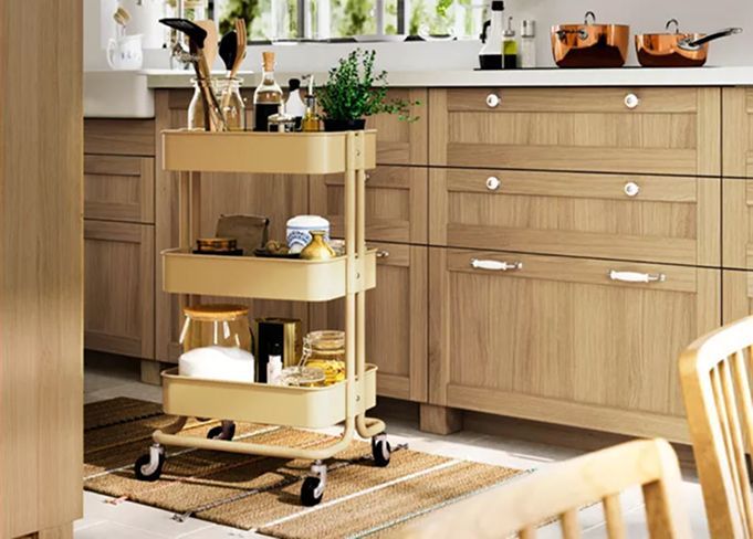 A RÅSKOG trolley stands on a striped RAKLEV flatwoven rug in front of a METOD kitchen with wood FORSBACKA fronts.