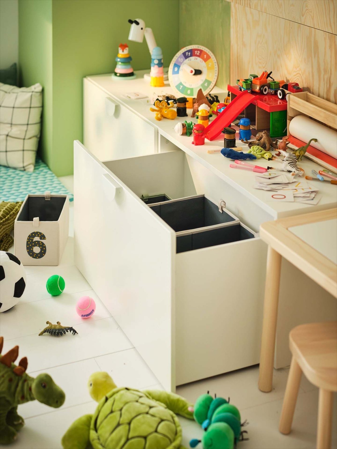 A still from a video showing a storage unit in a children's bedroom. Toys surround the open drawer.