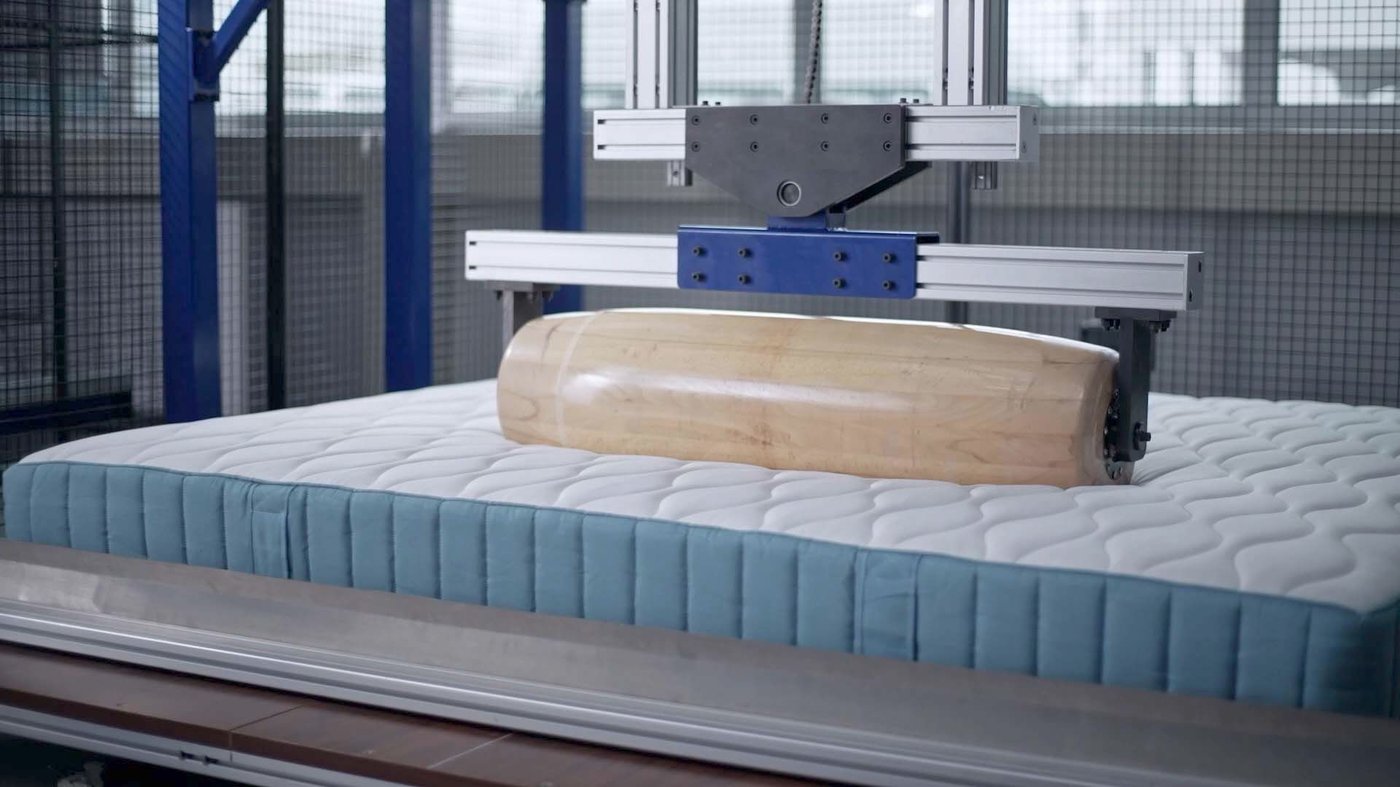In a test lab, a mattress undergoes a roller test.