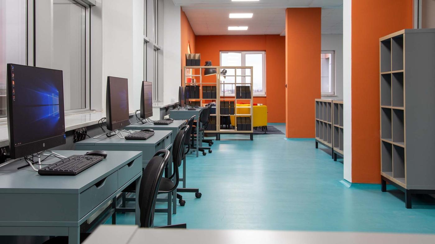 Computers on desks with office chairs in a library space at the International Burch University.
