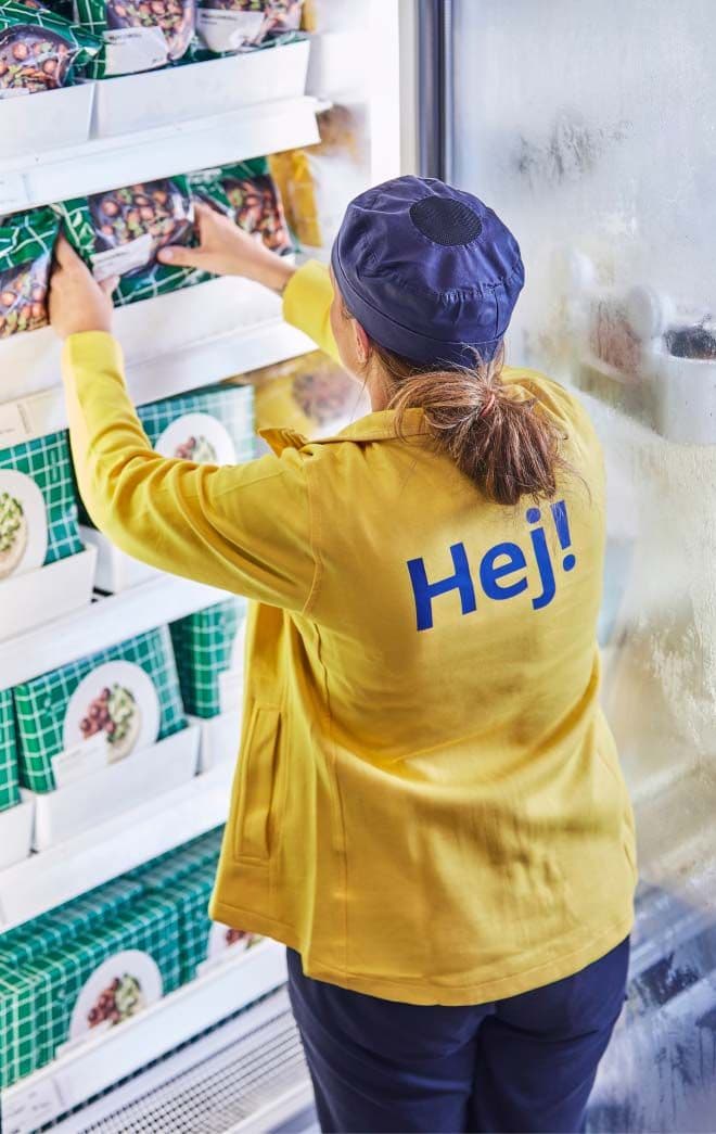 An IKEA co-worker stacks the shelves of the frozen food section.