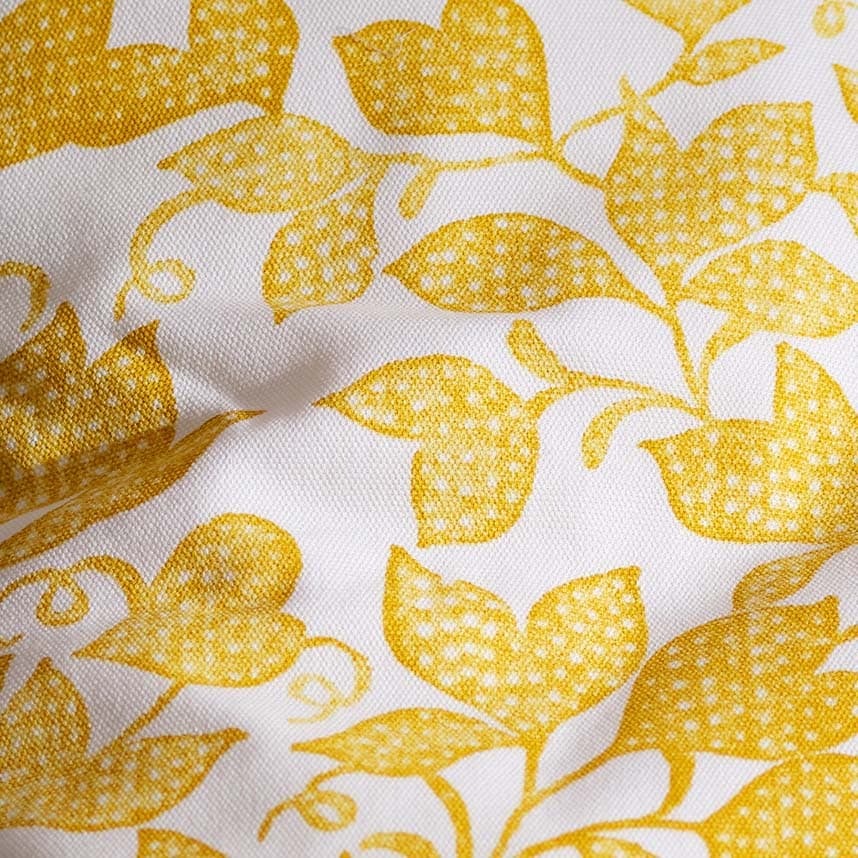 Close-up of white textile with yellow floral pattern.