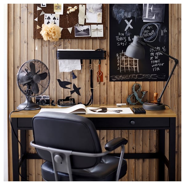 Postavljanje kućnog ureda: drveni stol sa stolicom, ventilatorom, svjetiljkom; ploče od pluta i krede iznad, ukrašene bilješkama i fotografijama.
