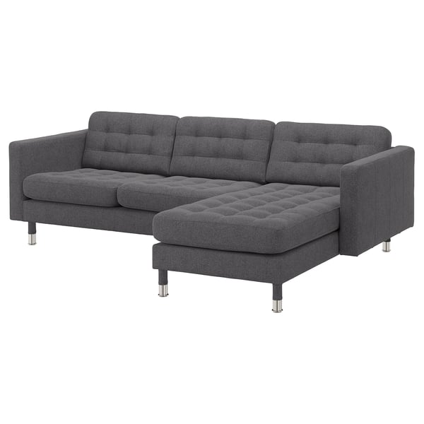 Moderna tamnosiva sofa u obliku slova L s čupavim sjedalima. Čelične noge, elegantan dizajn.
