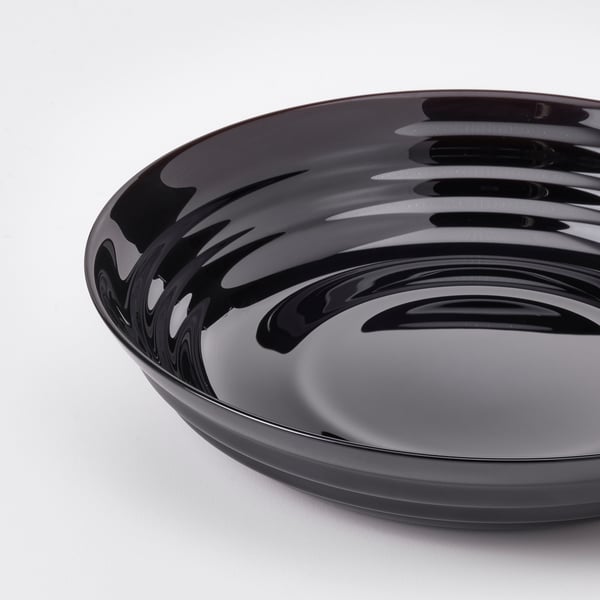 Crna sjajna staklena zdjela s glatkim, zaobljenim rubovima i reflektirajućom površinom.