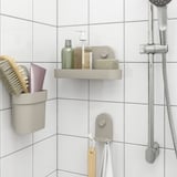 Bež organizatori za kupaonicu: polica s toaletnim potrepštinama, šalica s četkom, kuka s ručnicima.