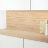 Drveni kuhinjski pult sa svijetlom drvenom pločom, koji drži dasku za rezanje i malu vazu.