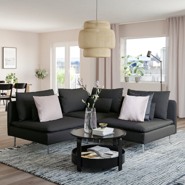 Moderan dnevni boravak s velikom crnom sekcijskom sofom SÖDERHAMN, elegantnim stolićem za kavu, elegantnom visećom svjetiljkom i velikim prozorima s pogledom na grad.